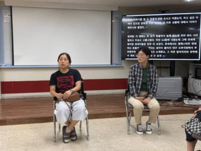 들다방 상영회 끝나지 않는 밤 상영 후 관객과의 대화 자리, 불 밝힌 강의실 앞쪽에 두 사람이 나와 앉아 있다.