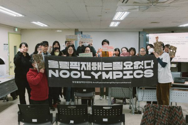 검정 가로 현수막 올림픽 재해는 필요없다. NO OLYMPICS를 모두 함께 모여 들고 있는 사람들 단체 사진