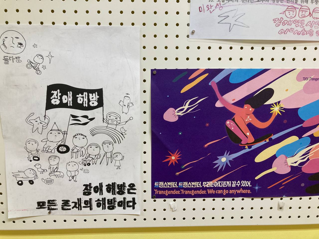 들다방 복도 벽면 게시판에 나란히 붙어 있는 들다방 장애해방 포스터와 이번 트랜스젠더 가시화의 날 포스터 촬영 사진.