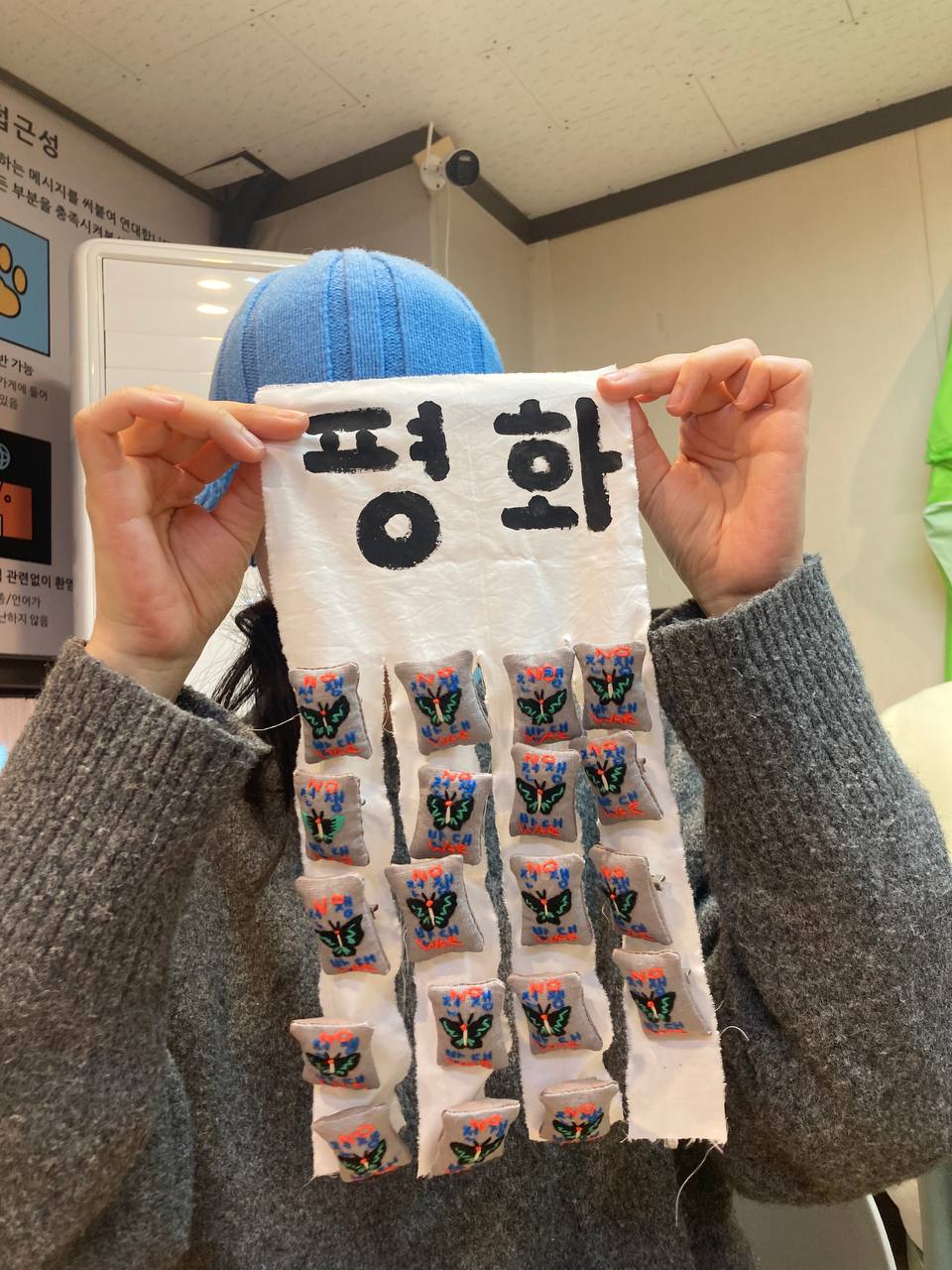 평화를 바라는 수공예 뱃지를 든 유희 작가님과 뱃지 약 20개 주렁주렁.